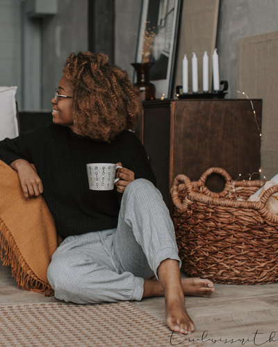 a mom smiling with a coffee and a basket system nearby